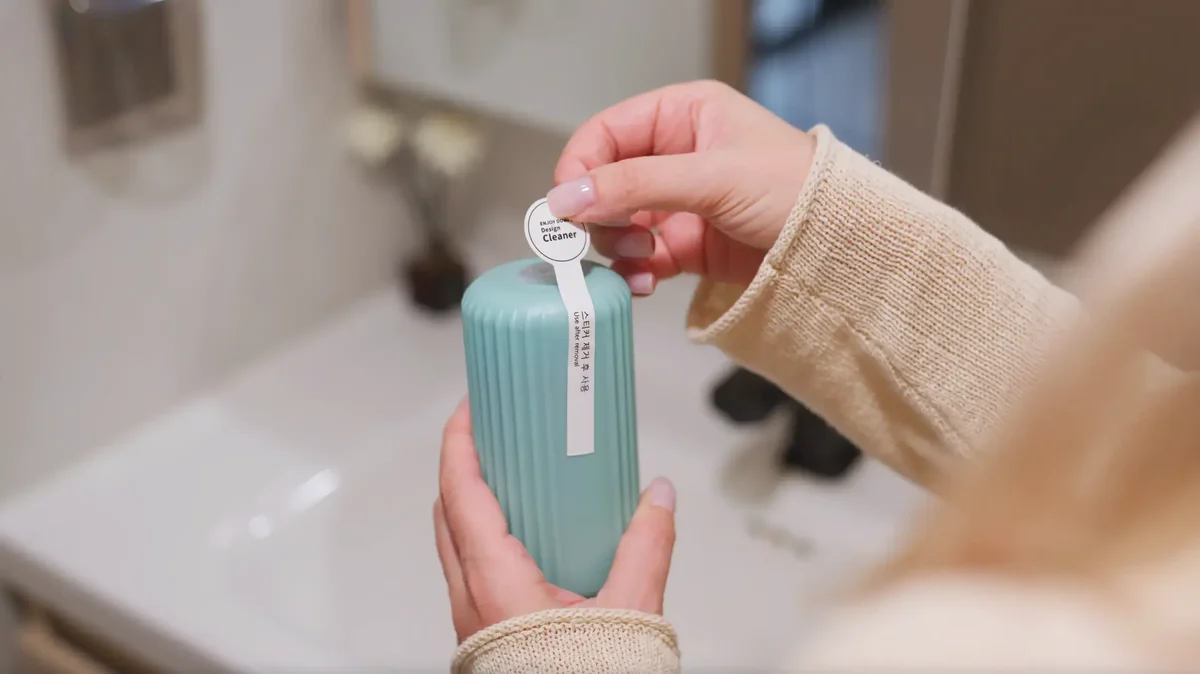 A Whooshie toilet cleaner in hand, ready to drop into the tank